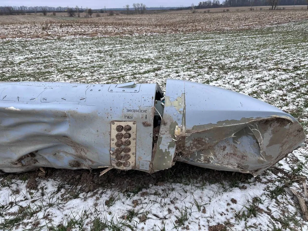 The crumpled silver body of a Kh-101 cruise missile lying in a snowy field